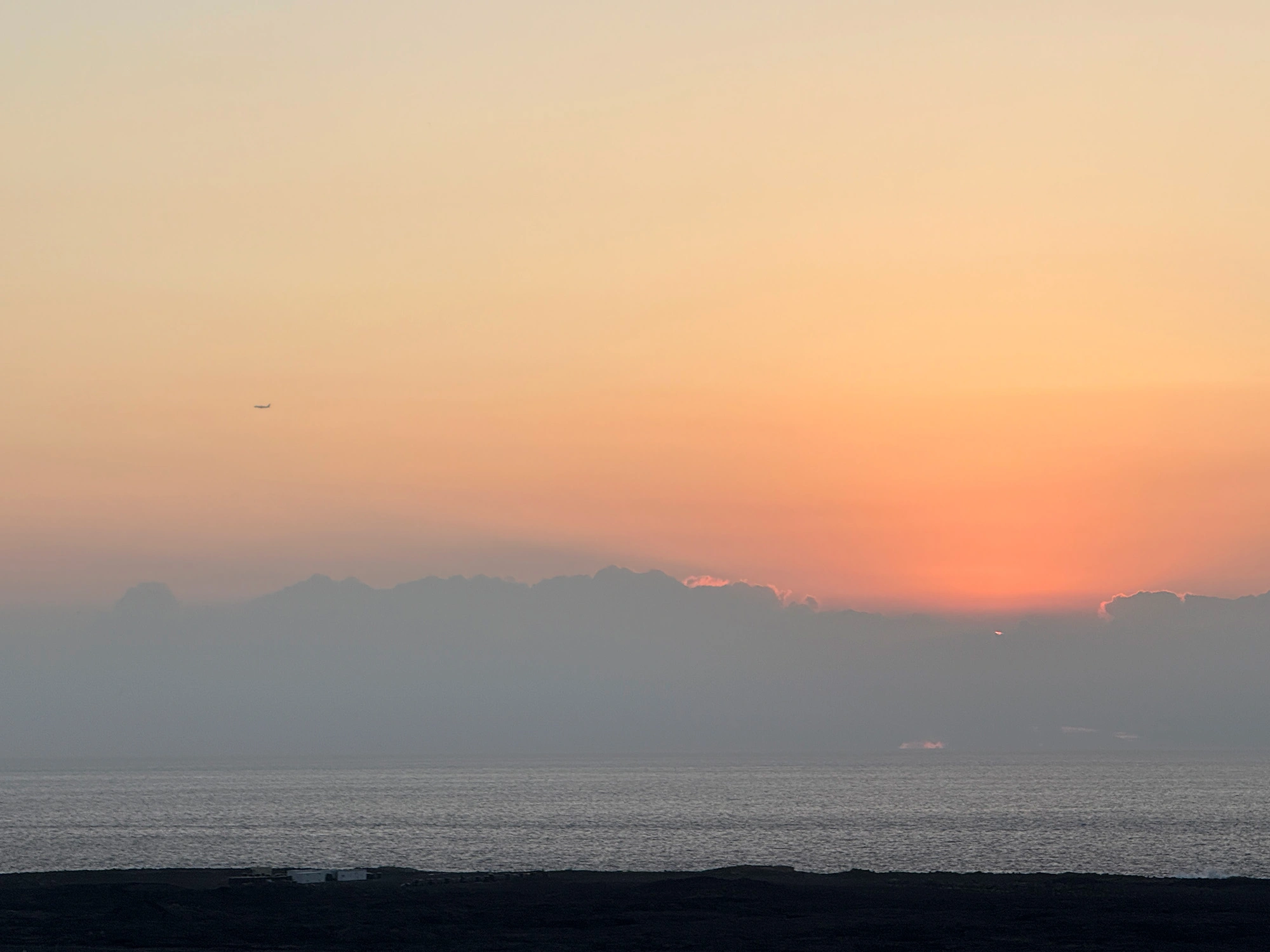 Sunset with a plane in the background.